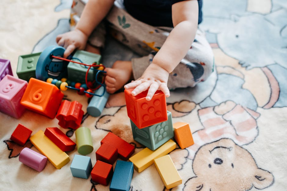 Toddler engaging with vibrant toy blocks on a patterned rug in a playful setting.